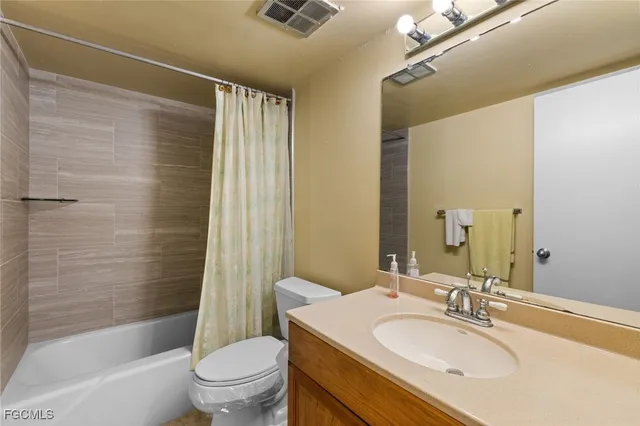a bathroom with a sink a toilet a mirror a bathtub and shower