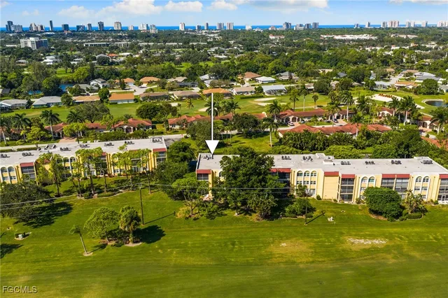 an aerial view of residential houses with outdoor space and trees