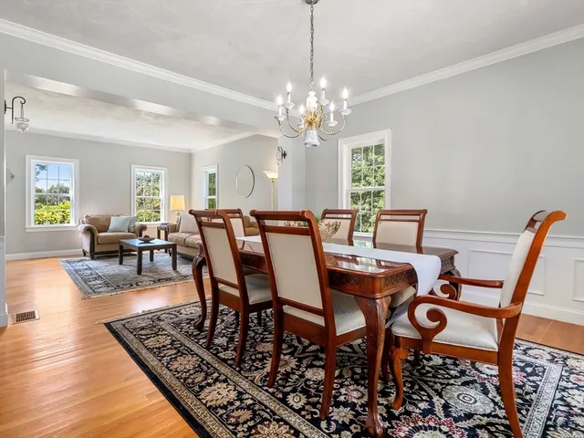 a view of a dining room with furniture a chandelier and wooden floor