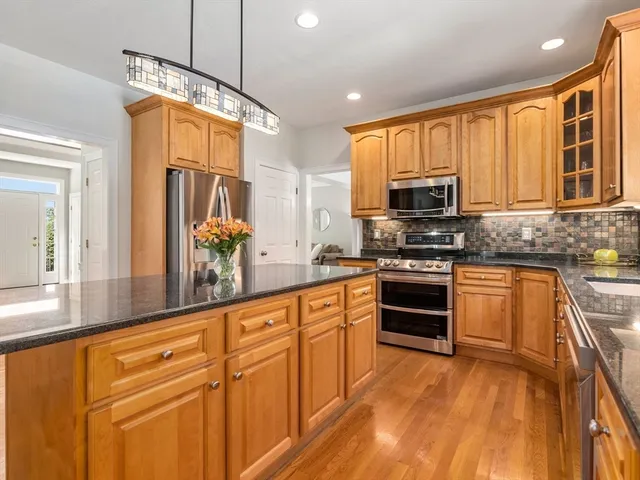 a kitchen with stainless steel appliances granite countertop a stove a sink and a refrigerator