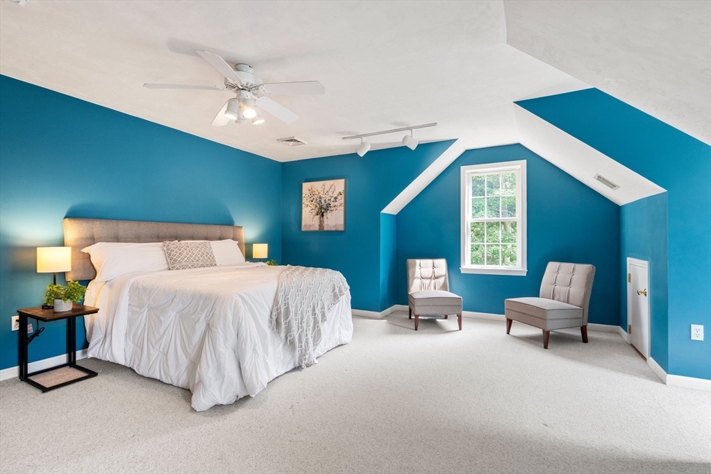 13 Breakneck Hill Road, Unit 1 Hopkinton, MA 01748 - Photo 21 of 37 a spacious bedroom with a bed and a chandelier