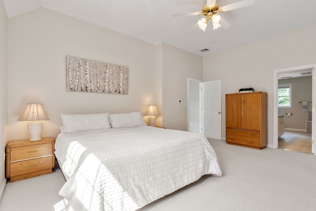 13 Breakneck Hill Road, Unit 1 Hopkinton, MA 01748 - Photo 23 of 37 a bedroom with a bed and a chandelier