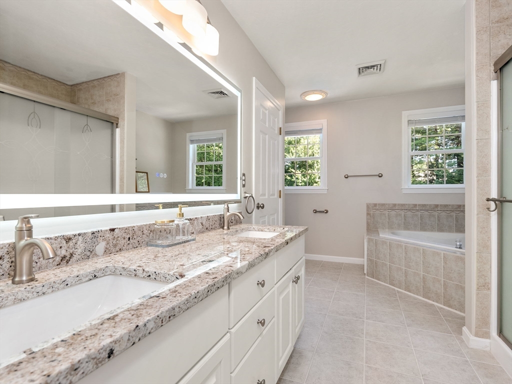 13 Breakneck Hill Road, Unit 1 Hopkinton, MA 01748 - Photo 25 of 37 a bathroom with a granite countertop sink and a bathtub