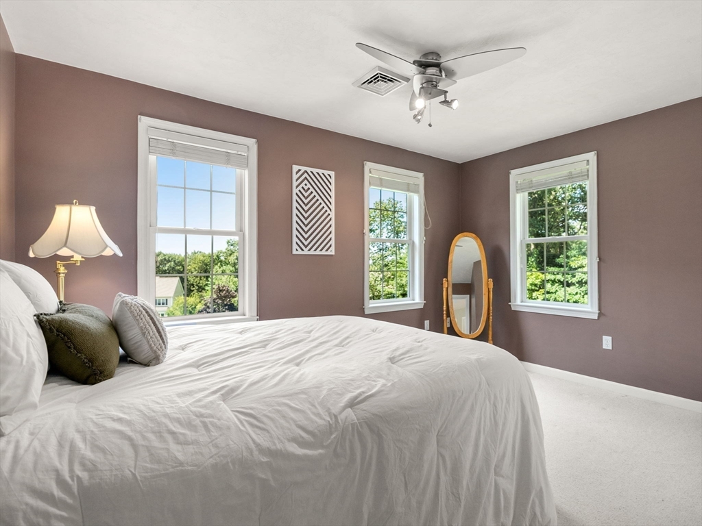 13 Breakneck Hill Road, Unit 1 Hopkinton, MA 01748 - Photo 33 of 37 a bedroom with a bed window and a chandelier