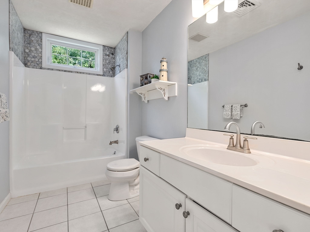 13 Breakneck Hill Road, Unit 1 Hopkinton, MA 01748 - Photo 34 of 37 a bathroom with a sink a toilet and a mirror
