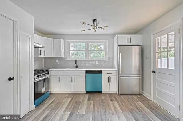 a kitchen with white cabinets a sink and appliances