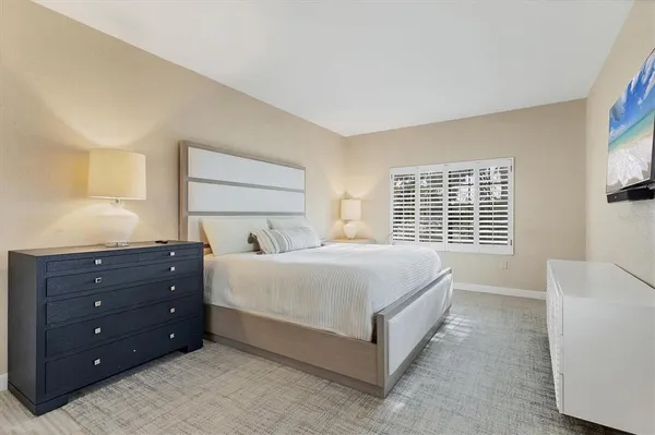 a large bed sitting in a bedroom next to a window and a larger closet