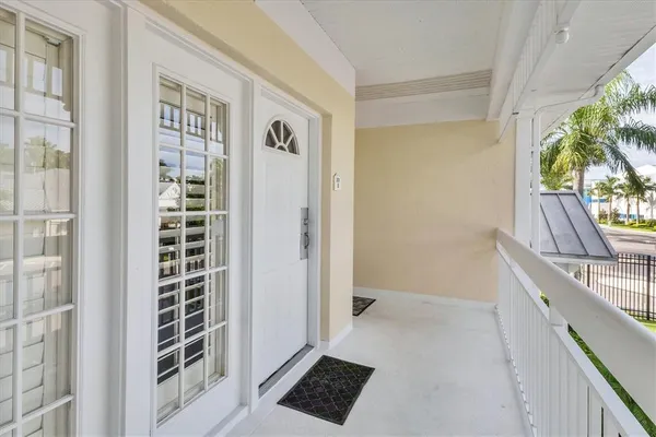 a view of a hallway to a livingroom with wooden floor and a window