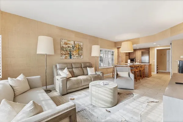 a large bedroom with a large bed a couch and chandelier