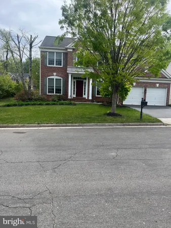 a front view of a house with a yard and trees