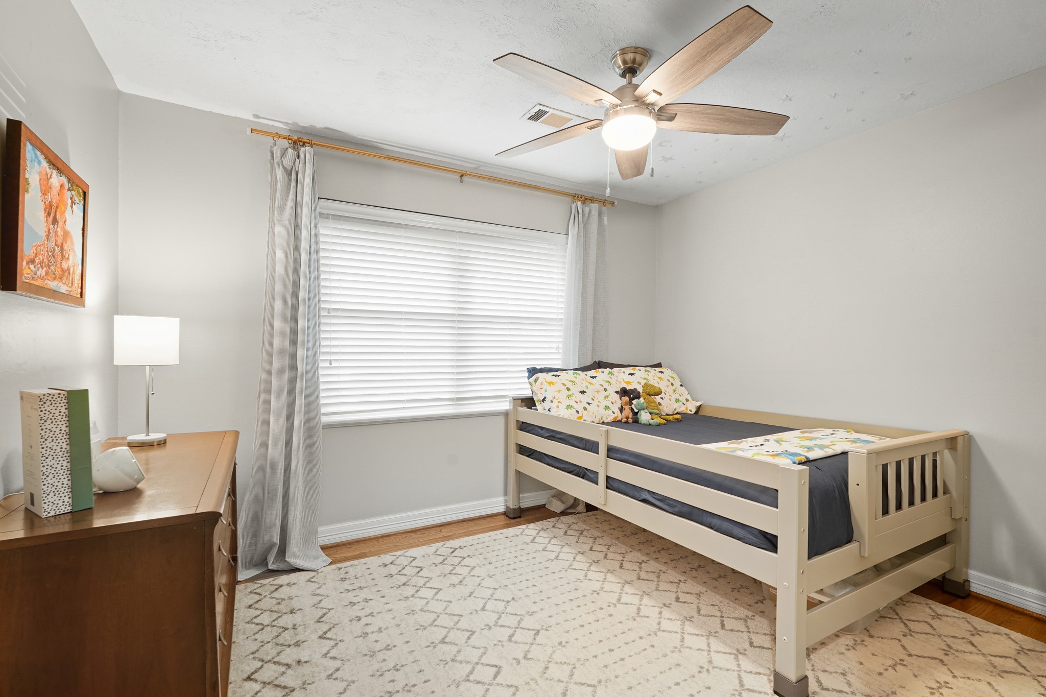 5242 Sanford Road Houston, TX 77035 - Photo 26 of 34 Secondary bedroom complete with hardwood flooring, natural light, ceiling fan and room to create the perfect space for family or friends!