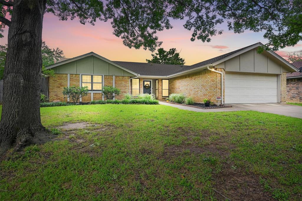 View of front of property with an attached garage, concrete driveway, a front yard, and board and batten siding