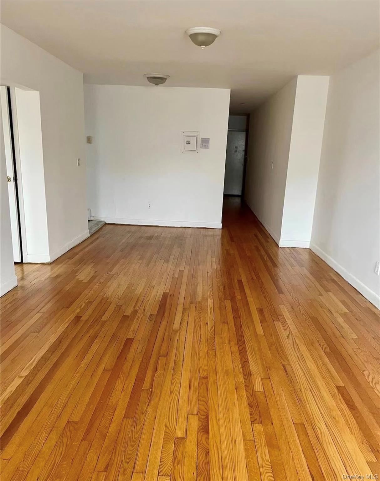7 Bond Street, Unit 3J Great Neck, NY 11021 - Photo 5 of 10 an empty room with wooden floor