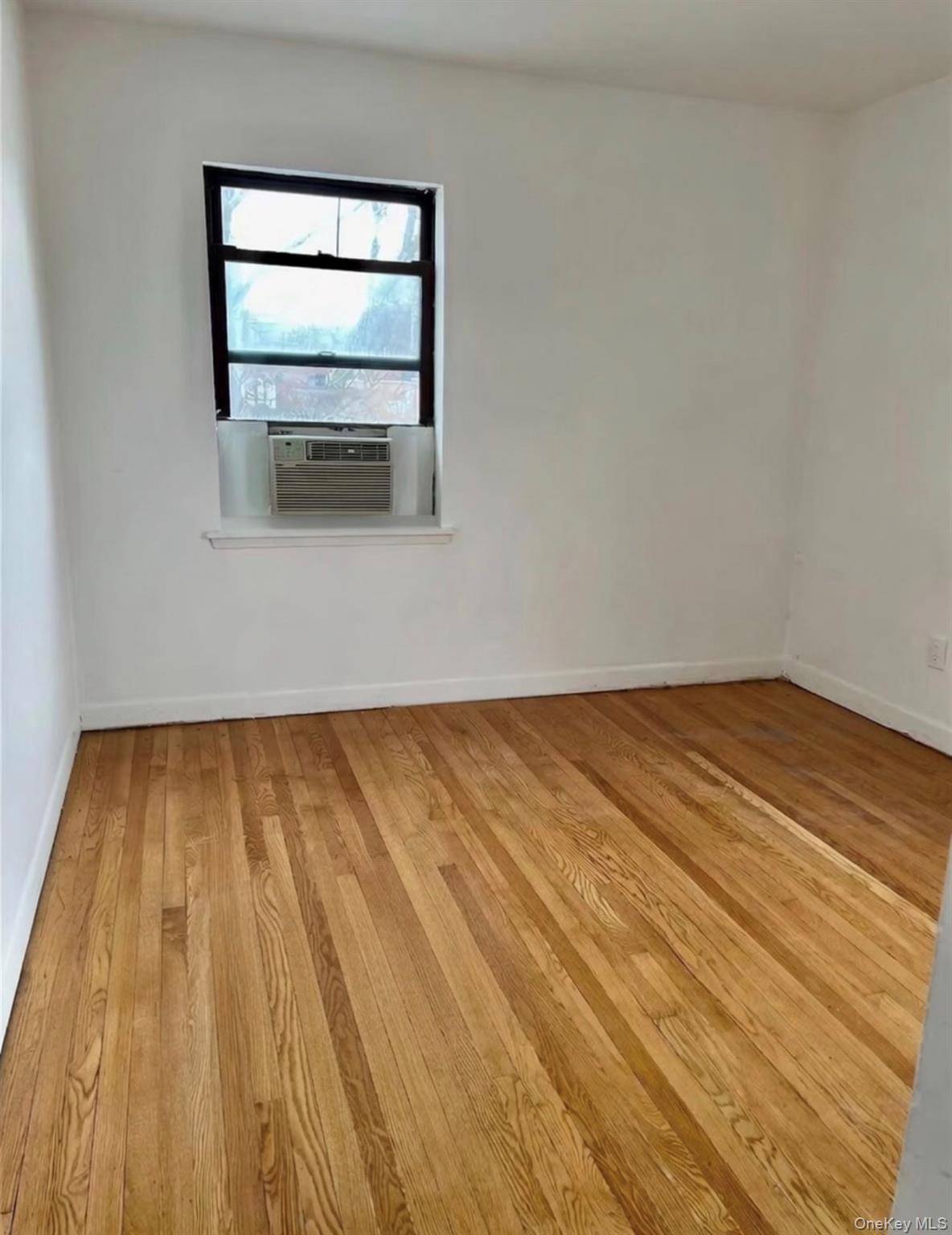 7 Bond Street, Unit 3J Great Neck, NY 11021 - Photo 7 of 10 a view of empty room with wooden floor and fan