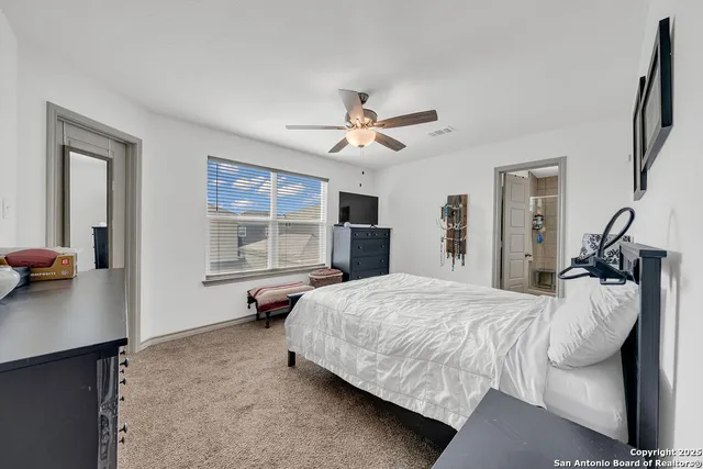 a spacious bedroom with a bed and a chandelier