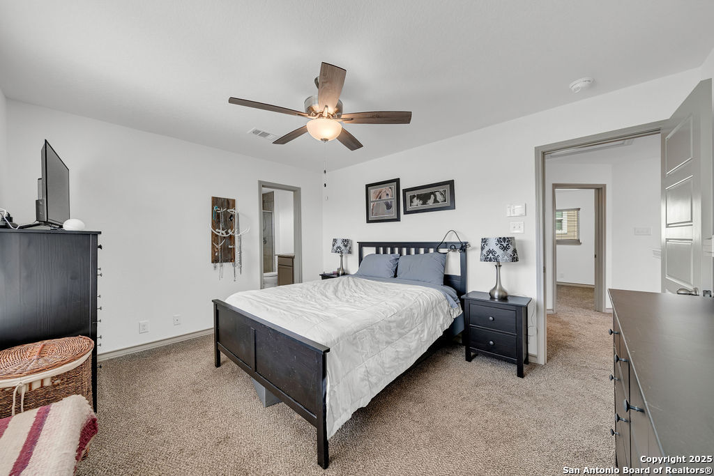 2045 Silver Oaks, Unit 18B San Antonio, TX 78213 - Photo 12 of 20 a spacious bedroom with a bed and a chandelier
