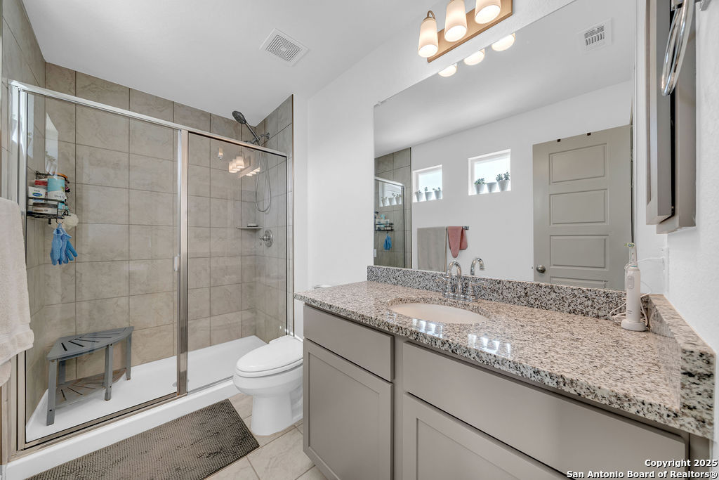 2045 Silver Oaks, Unit 18B San Antonio, TX 78213 - Photo 13 of 20 a bathroom with a granite countertop sink a toilet a mirror and shower