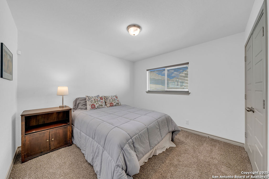2045 Silver Oaks, Unit 18B San Antonio, TX 78213 - Photo 14 of 20 a bedroom with a bed and a lamp