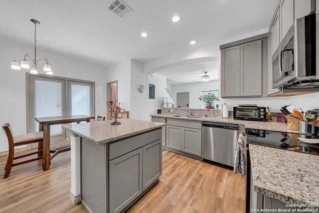 a kitchen with granite countertop a sink stove and cabinets