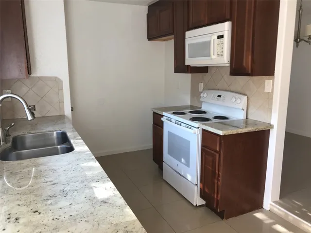 a kitchen with stainless steel appliances granite countertop a sink and a stove top oven