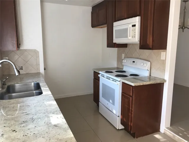 a kitchen with a sink stove and microwave