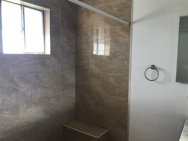 a bathroom with a granite countertop toilet and a shower