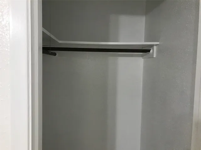 a view of a small space with wooden floor and a window