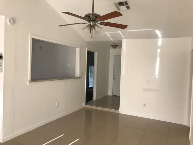 a view of an empty room with a ceiling fan