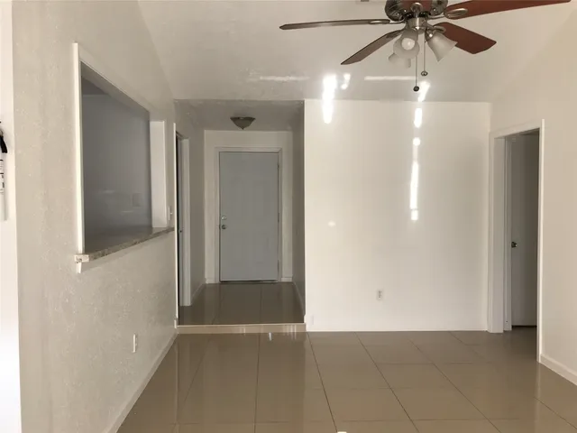 a view of a hallway with a chandelier fan and entryway