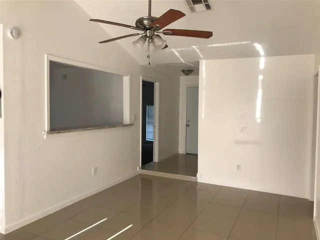 a view of a livingroom with a ceiling fan and wooden floor