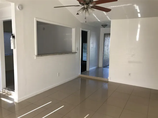 a view of an empty room with a ceiling fan
