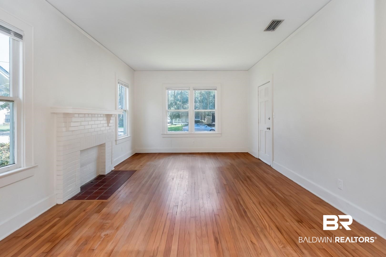112 South Fulton Street Mobile, AL 36606 - Photo 8 of 35 Unfurnished living room with a fireplace and hardwood / wood-style flooring