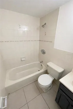 a white toilet and tub sitting next to a bathroom sink