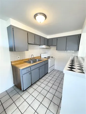 a kitchen with stainless steel appliances a sink stove and cabinets