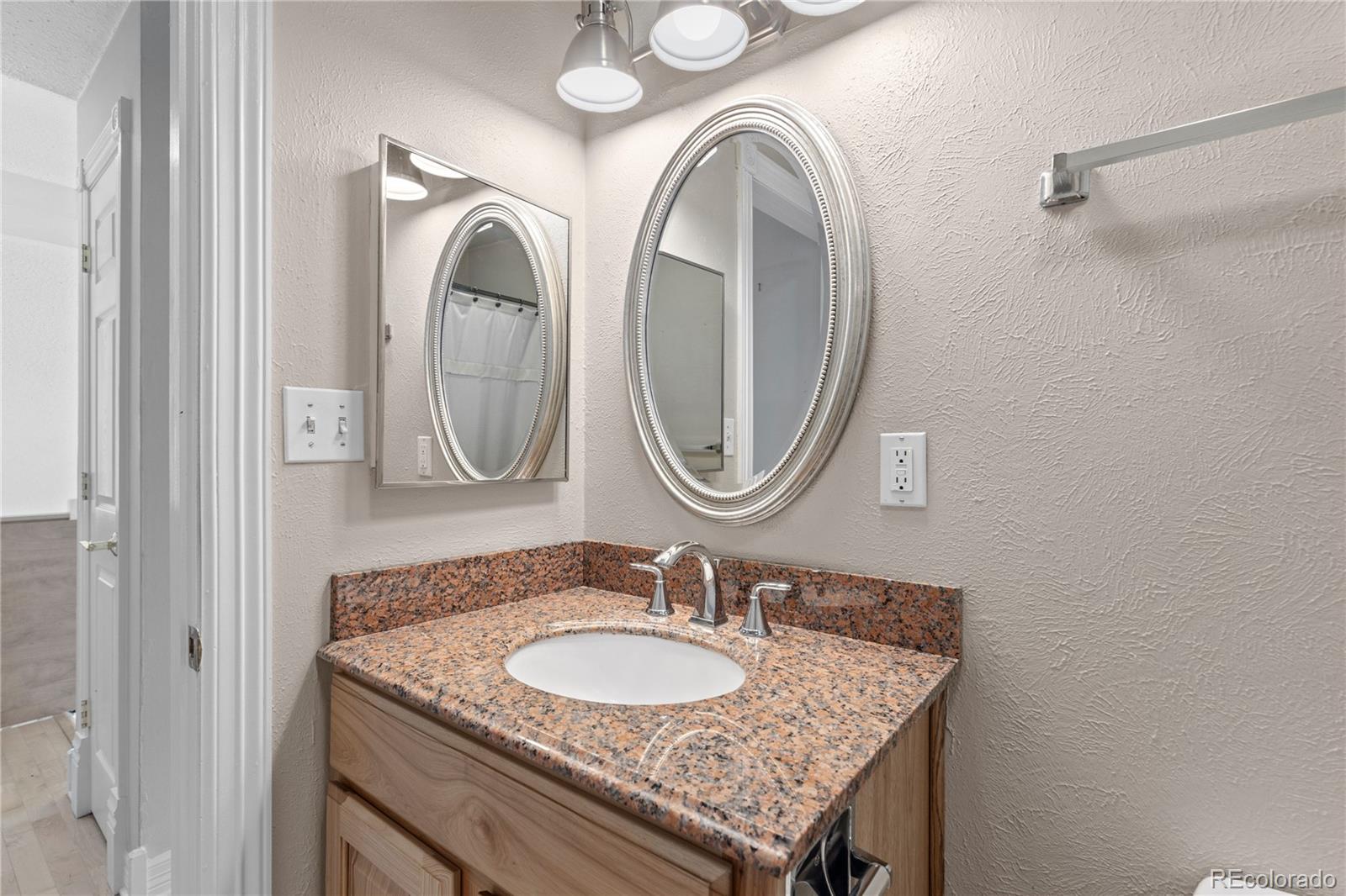 10684 Beas Drive Conifer, CO 80433 - Photo 24 of 38 a bathroom with a granite countertop double vanity sink and a mirror