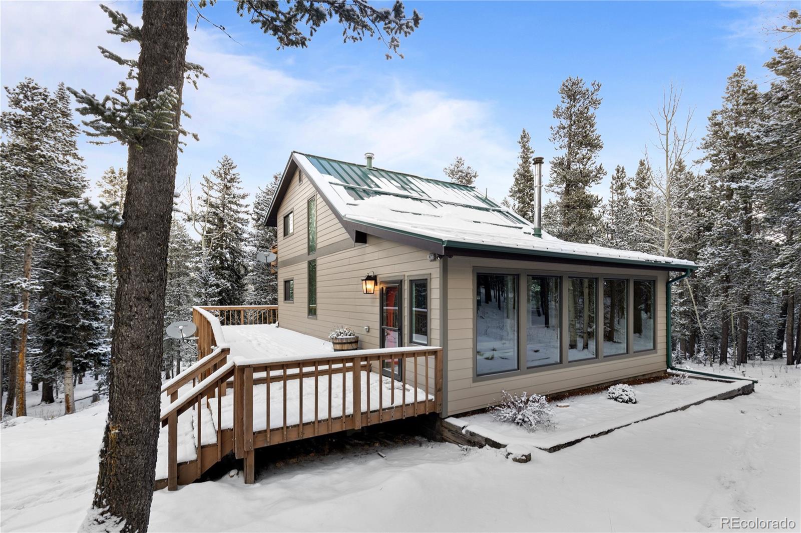 10684 Beas Drive Conifer, CO 80433 - Photo 34 of 38 a view of a house with a wooden deck and a backyard