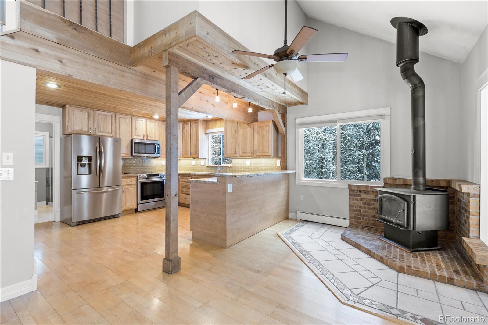 10684 Beas Drive Conifer, CO 80433 - Photo 7 of 38 a kitchen with stainless steel appliances a stove a refrigerator and furniture