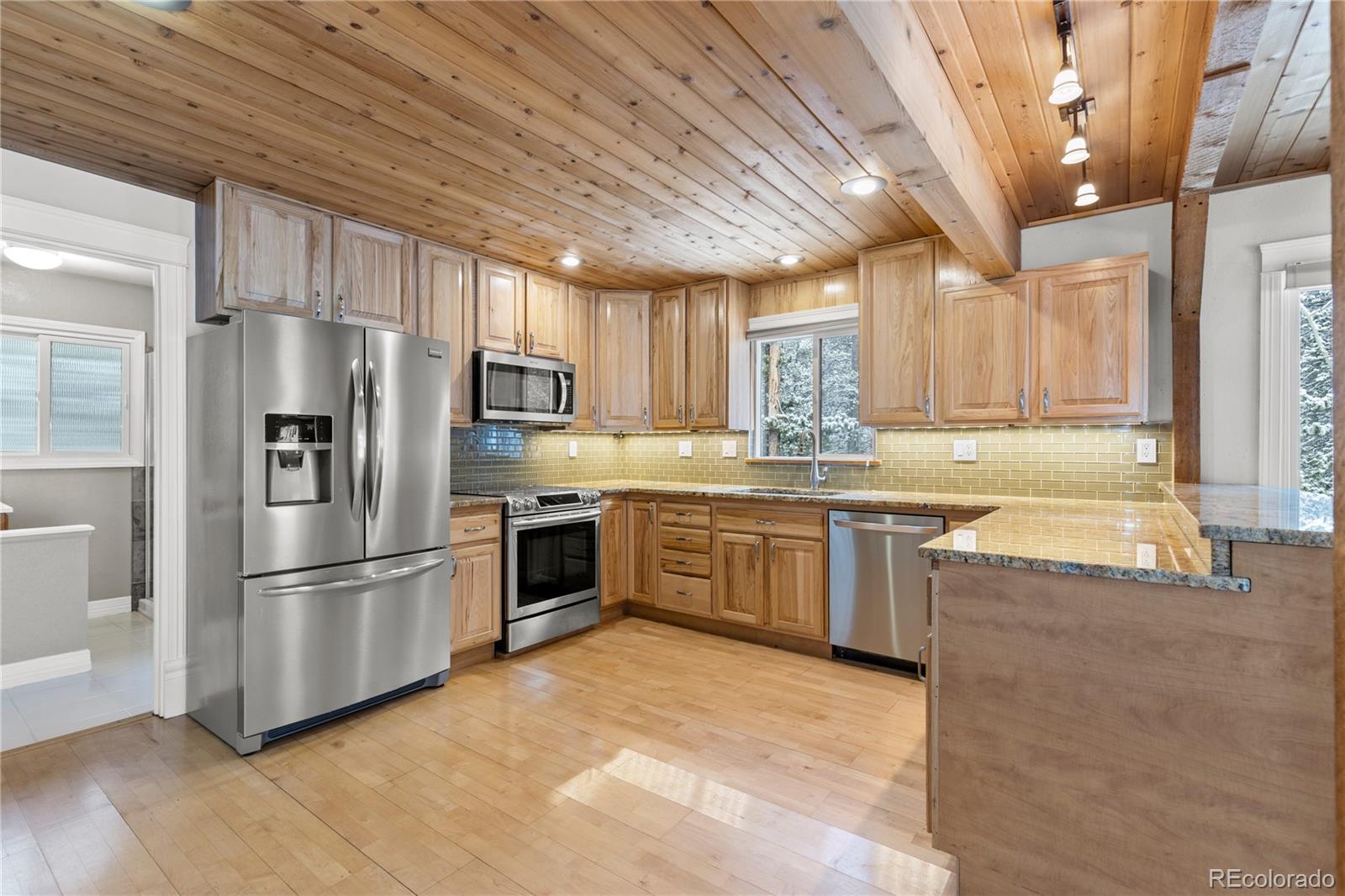 10684 Beas Drive Conifer, CO 80433 - Photo 8 of 38 a kitchen with granite countertop a refrigerator stove top oven and sink