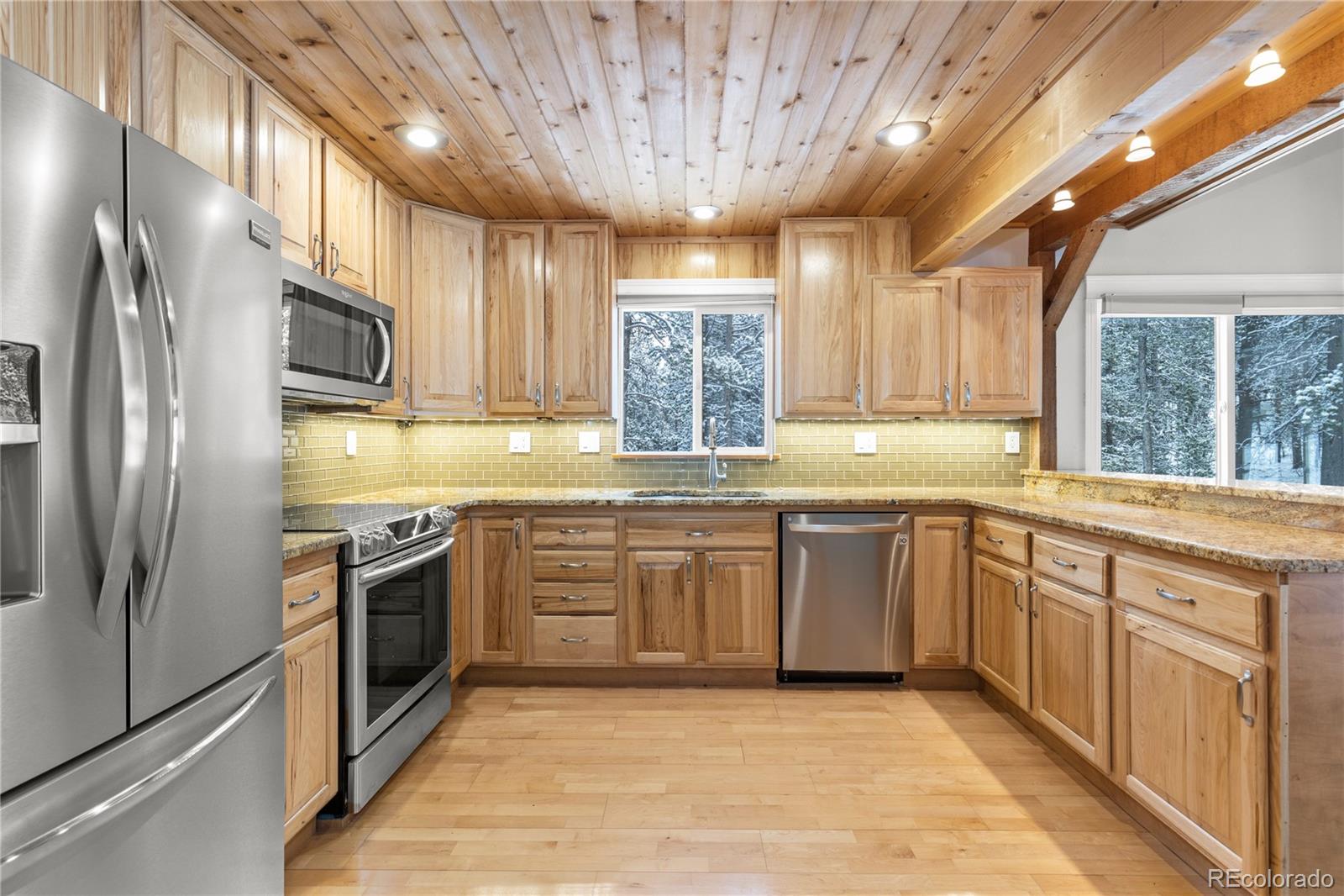 10684 Beas Drive Conifer, CO 80433 - Photo 9 of 38 a kitchen with stainless steel appliances granite countertop a sink a stove a refrigerator cabinets and a window