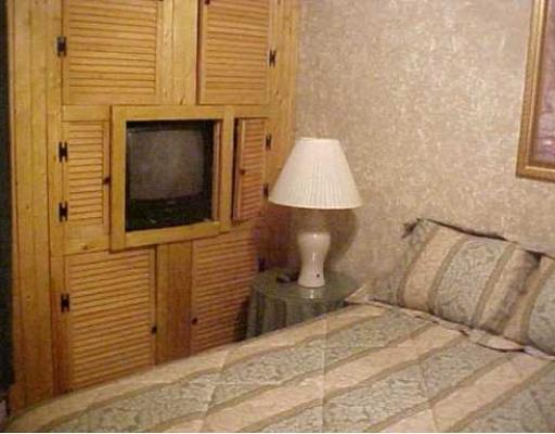 3938 Surfside, Unit 2223 2223 Corpus Christi, TX 78402 - Photo 3 of 9 a bed room with a bed and a night stand