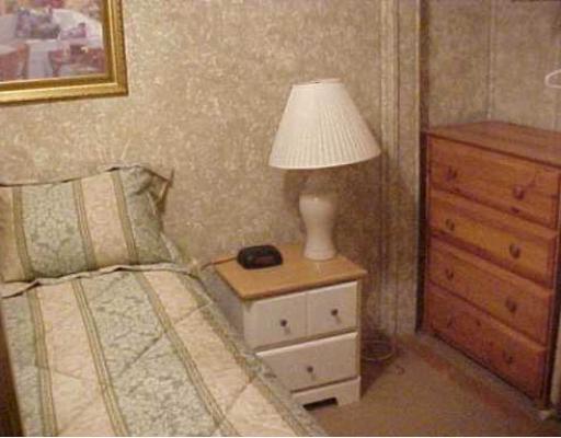 3938 Surfside, Unit 2223 2223 Corpus Christi, TX 78402 - Photo 6 of 9 a bed room with a bed and a night stand