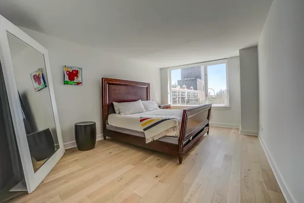 a bedroom with a bed and a refrigerator