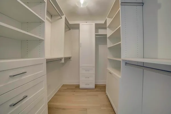 a view of walk in closet with empty racks