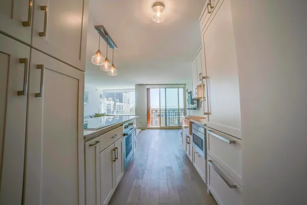 a kitchen with cabinets and wooden floor