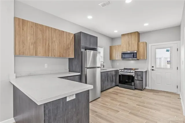 a kitchen with refrigerator cabinets and wooden floor