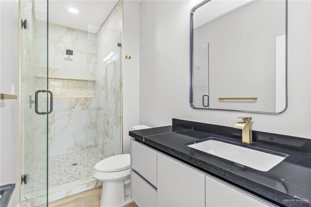 103 Yosemite Drive, Unit 3 Mission, TX 78572 - Photo 7 of 9 a bathroom with a granite countertop sink toilet and shower