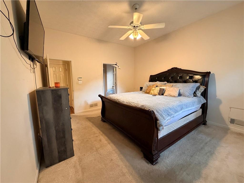 426 Pates Lake Court Hampton, GA 30228 - Photo 33 of 60 a bedroom with a bed flat screen tv and a chandelier
