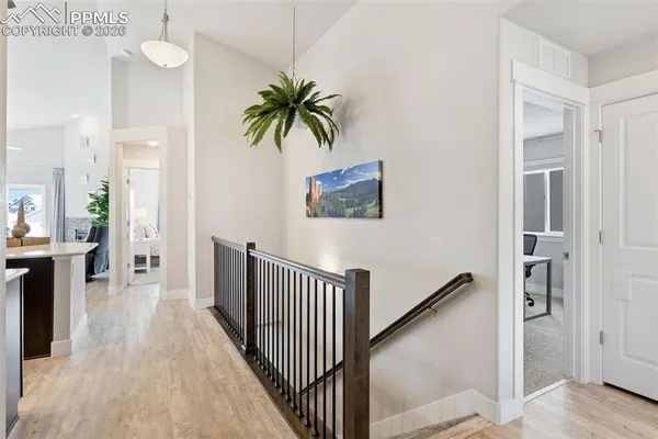a view of a hallway with wooden floor and a potted plant