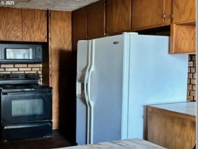 a white refrigerator freezer and a stove sitting inside of a kitchen