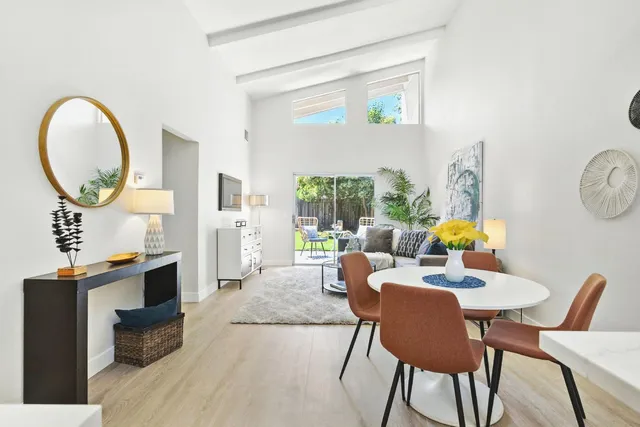 a dining room with furniture a mirror and a flat screen tv